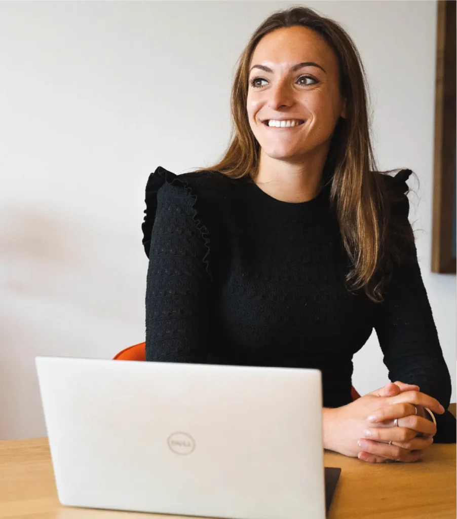 Roos lachend achter een laptop